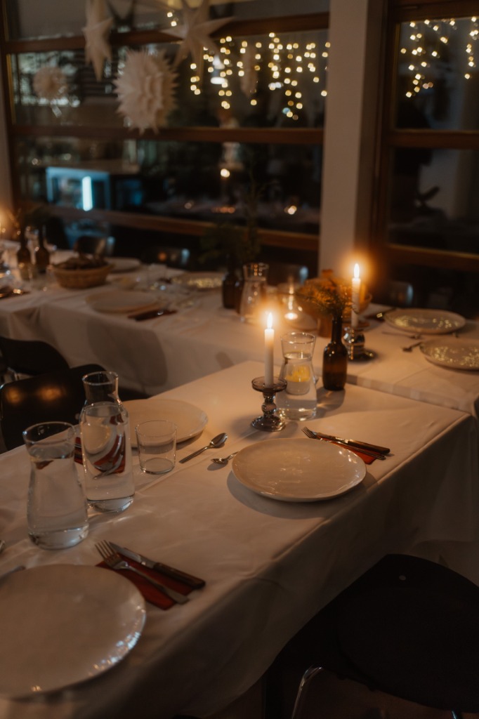 Stimmungsvoll eingedeckte Tafel mit warmem Kerzenlicht und Sternendekoration im co:Lab