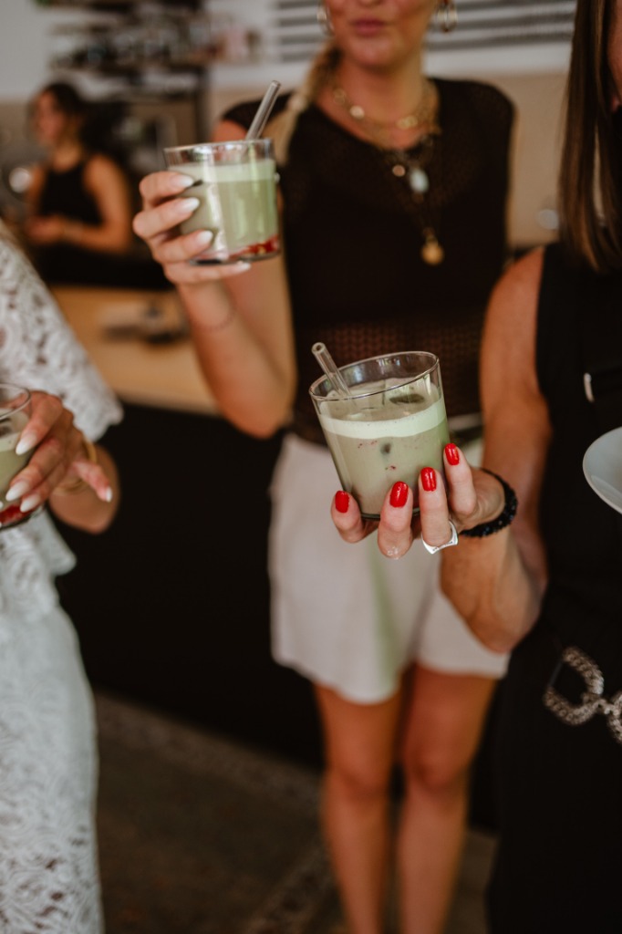 Gäste halten stolz selbst zubereitete, erfrischende Matcha-Latte-Kreationen mit Glasstrohhalmen im co:Lab